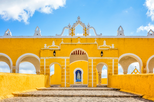 Izamal, Yucatan, Mexico, known as “The Yellow City”, is a major Mayan archeological site and home of Bishop Diego Landa, who burned most pre-columbian Mayan codices. The conqueror’s city is built over the ruins. In 1549, a Franciscan monastery was built on the platform of the main pre-Hispanic pyramid. The relatively small town at the time of the conquest was greatly expanded in the middle of the 16th century by the resettlement of the scattered population of the surrounding area, which lived for some time in politically divided districts. In Izamal, auxiliary troops of the Spaniards from central Mexico settled in a small settlement called La Concepción, which kept their native language for several decades.
