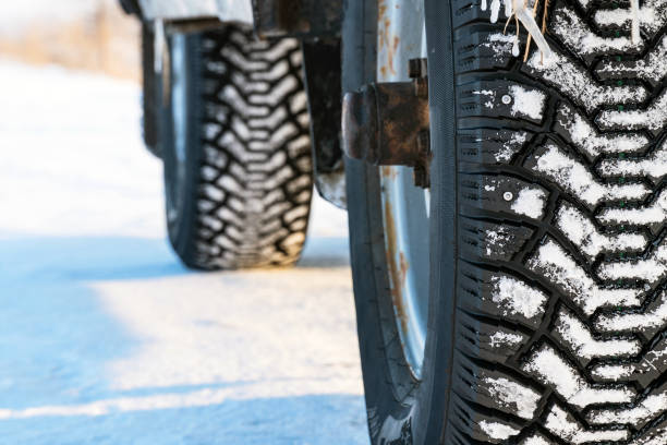istock Studded winter car tires on winter road 918143106