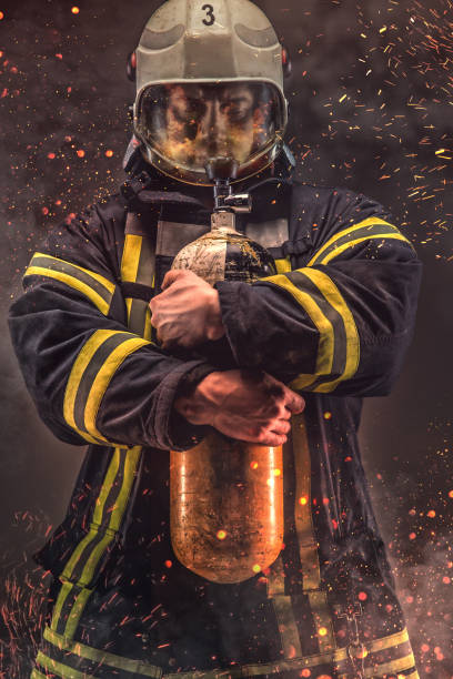 istock Firefighter in helmet and mask holds oxygen tanks. 918143280