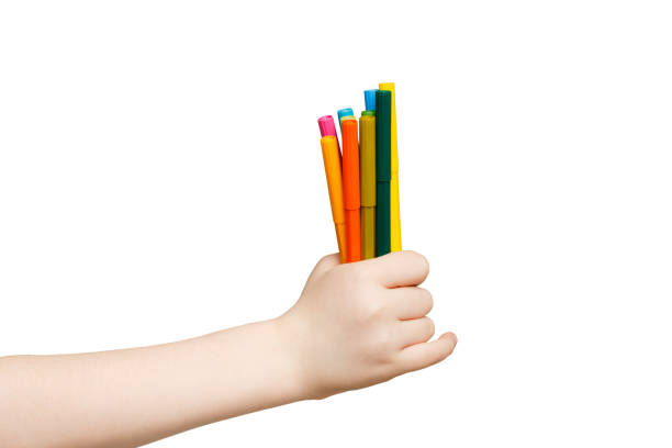 Children's hand holding stack of colorful markers. isolated on white background. Art, creativity, education concept