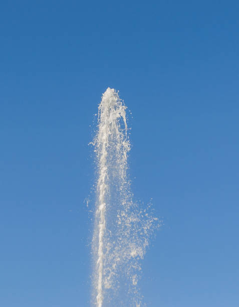 ein großen strom von reinem wasser sprudelt oben unter druck auf dem hintergrund des blauen himmels - fountain water physical pressure splashing stock-fotos und bilder