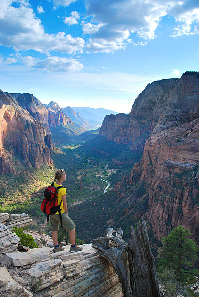 Narrows riverside trail walk in Zion National Park with young woman girl exploring hike by river on summer day with backpack