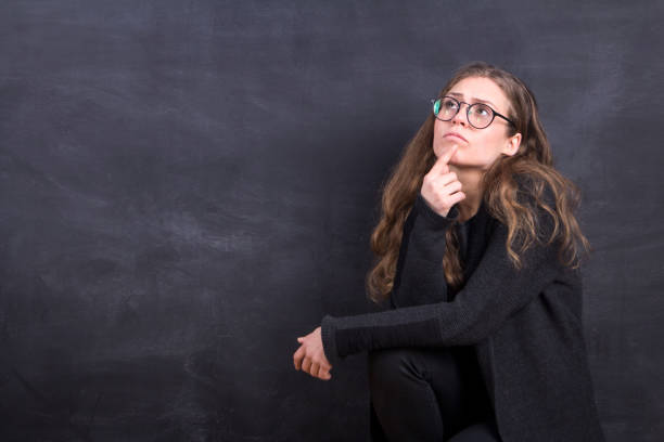 istock Young Woman Thinking Front Of The Blackboard 918154056