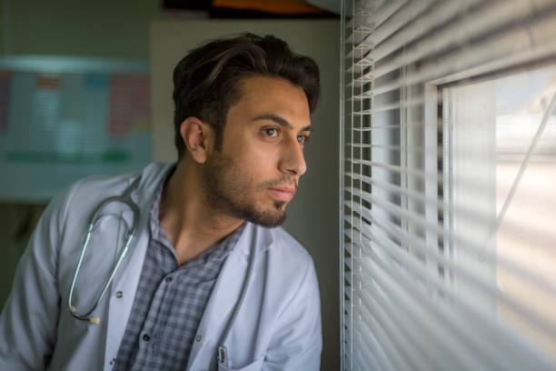 istock Confident doctor looking thru the window 918159246