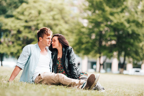 istock couple resting and flirting in the park 918162186