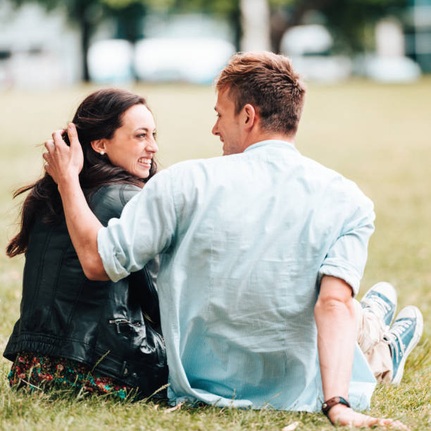 istock couple resting and flirting in the park 918162474