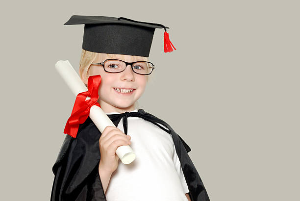 schoolboy in graduation cap isolated stock photo