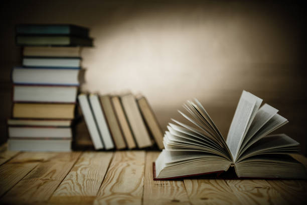 istock Open book on wood desk with blurred focus for background. 918168744