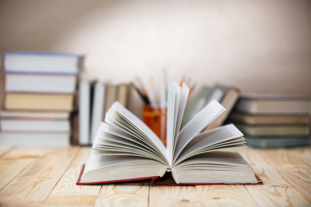 istock Open book on wood desk with blurred focus for background. 918168940