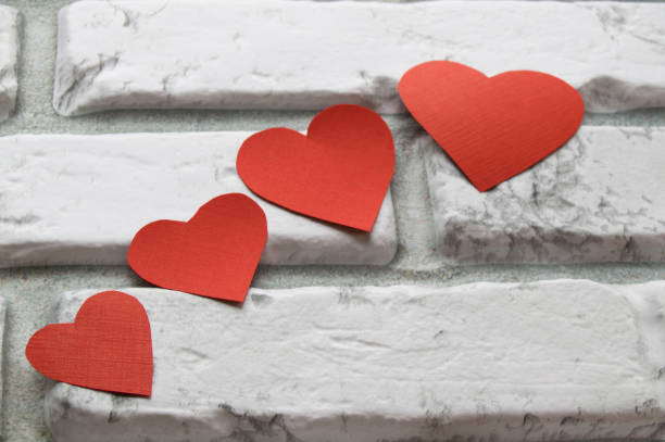 istock Four red heart Valentine's Day, white brick wall background 918173408