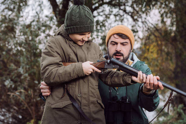 istock Father showing son how to load gun 918174856