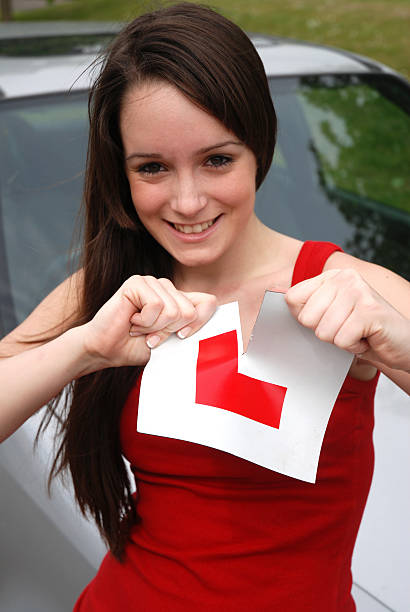 Pretty teenager ripping L plate stock photo