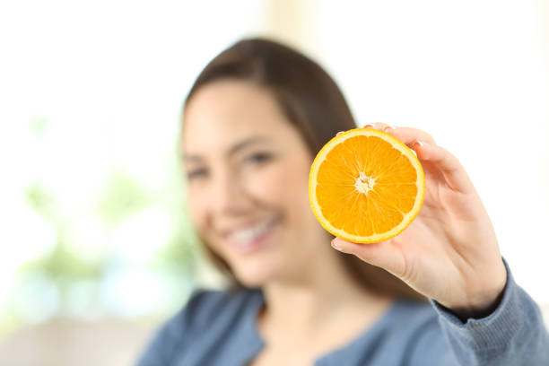 istock Happy woman showing an orange 918179362