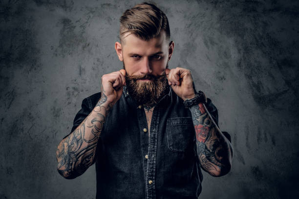 Bearded hipster with tattooe on his arms. stock photo