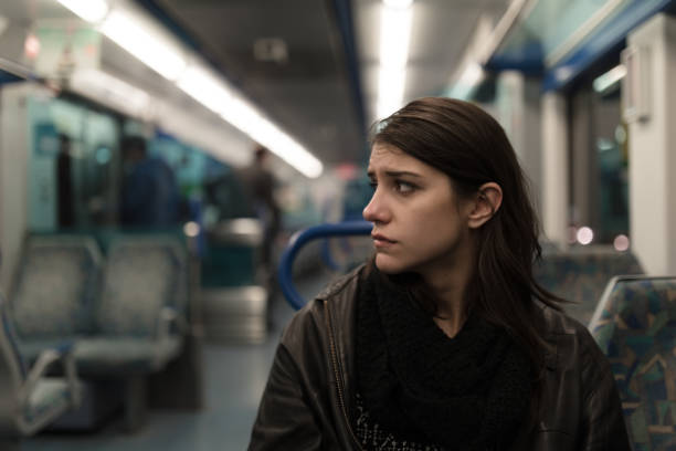 Sad depressive woman in train going home from work.Tired exhausted looking young lady getting away with train ride. stock photo