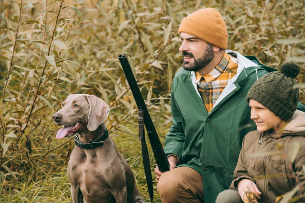 istock Father and son squatting in bushes at hunt 918180216
