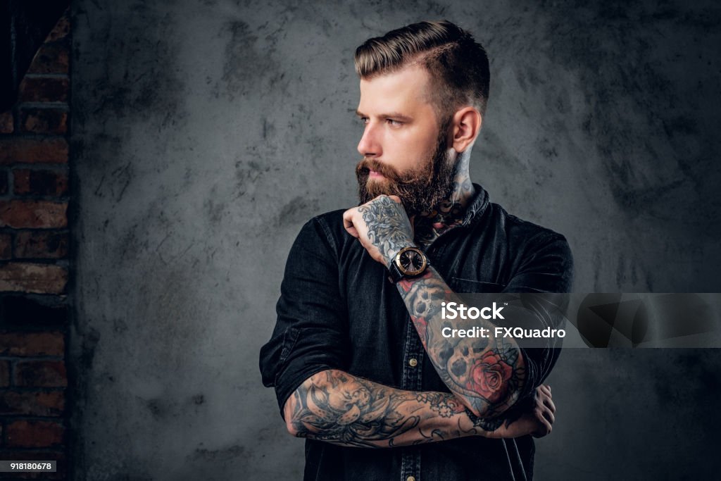 Hipster barbuto con tatuaggi sulle braccia. - Foto stock royalty-free di Tatuaggio
