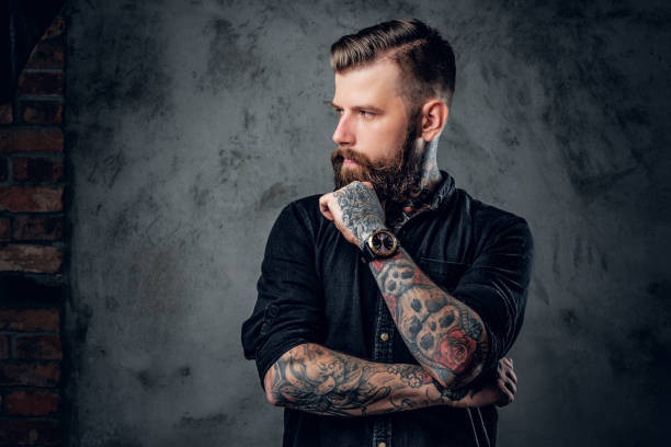 彼の腕に tattooe とひげを生やした流行に敏感。 - men hairdresser human hair hairstyle ストックフォトと画像