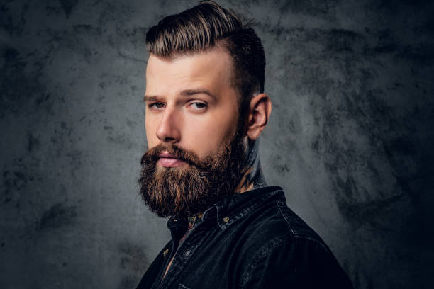 Bearded male in black shirt with tattoo on his neck. stock photo