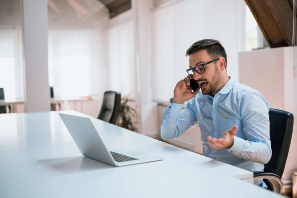 wütend geschäftsmann am telefon im büro - frustration computer confusion businessman stock-fotos und bilder