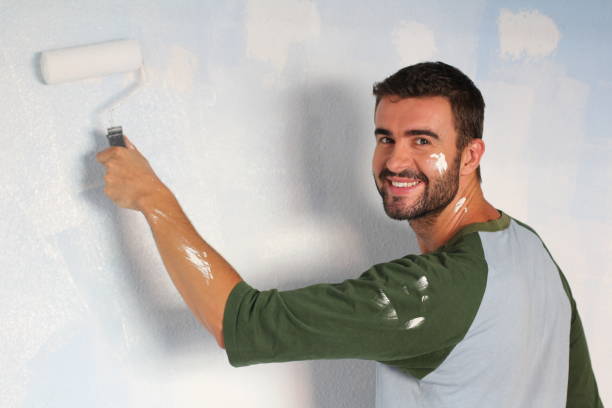 istock Joyful male painting wall with a roller 918201422
