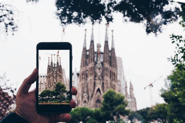 viajes concepto - turismo toma de fotos de la famosa iglesia de la sagrada familia con teléfono móvil inteligente, españa - barcelona - cataluña - destinos turísticos fotos fotografías e imágenes de stock