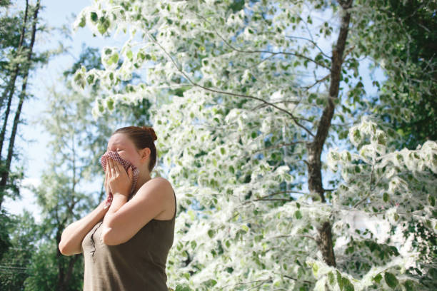 Young woman suffering spring pollen allergy. Poplar Bloom season
