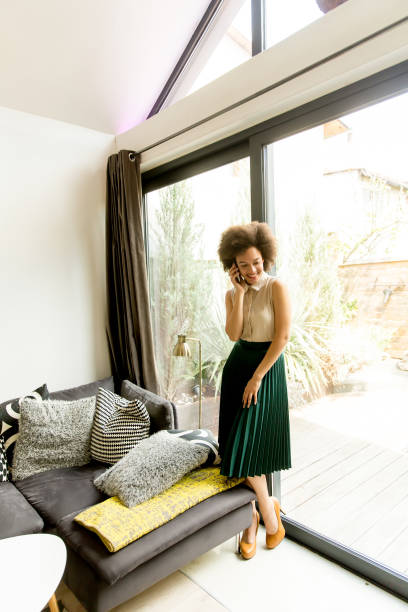 istock African american woman using mobile phone in the room 918212766