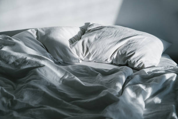 istock white crumpled bed with pillow and blnaket 918215520