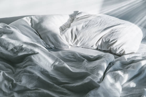 istock white crumpled bed with pillow and blnaket 918215606