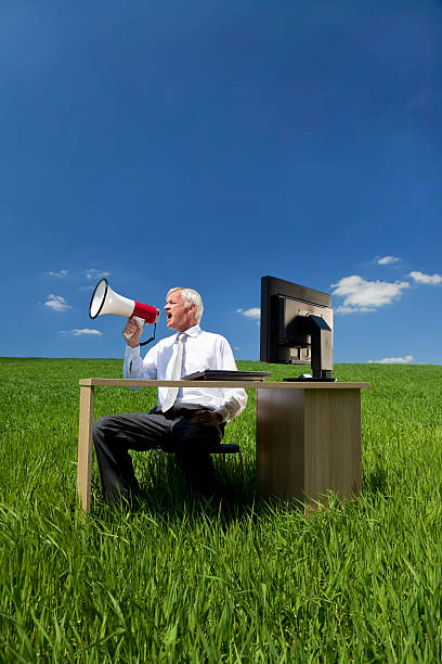 istock Business Concept Man Using Megaphone In A Green Field 91821856