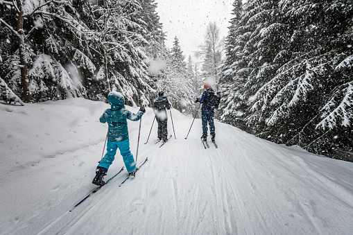 familia en paisaje de invierno cubierto de nieve en esquí-Cruz campo photo
