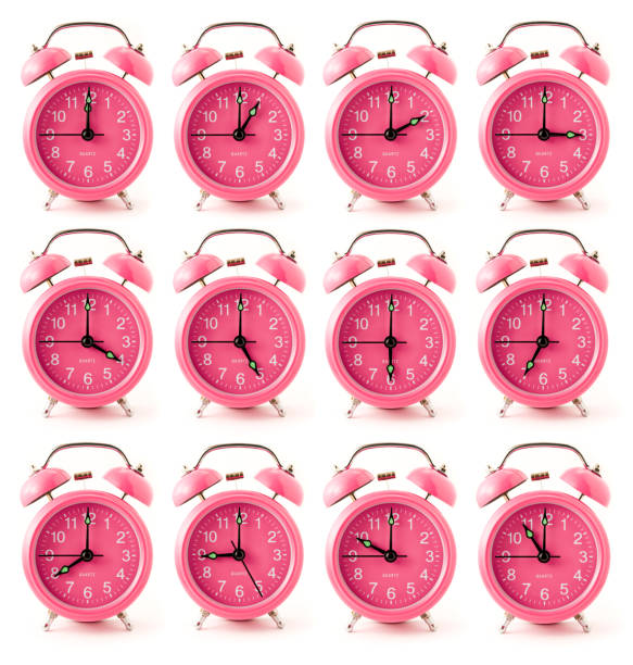 Set of 12 pink alarm clocks with different times stock photo