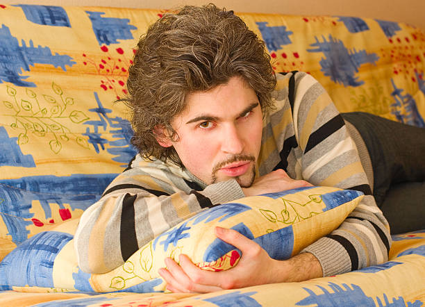istock Young serious handsome male on colourful sofa 91822823