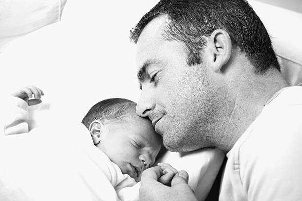 istock father holding his newborn baby 91823199