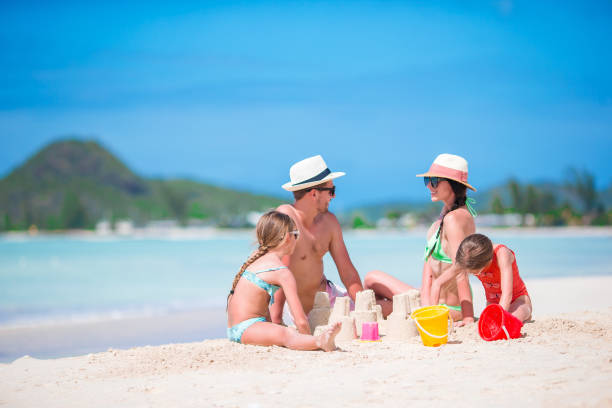 istock Family making sand castle at tropical white beach 918233058