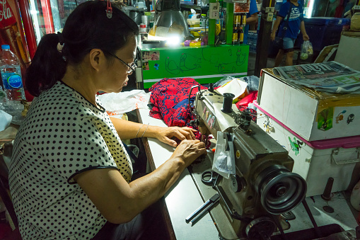 Bangkok, Thailand. January 2018. a woman sewing a gown in the Bangkok market, Thailand
