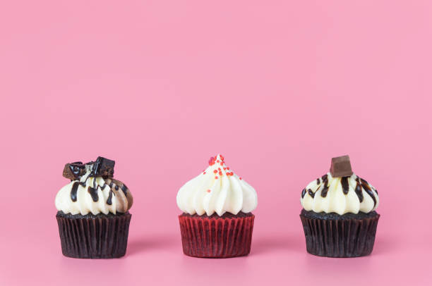 istock Three mini muffin cupcake on pink copy space background with copy space for text 918238074
