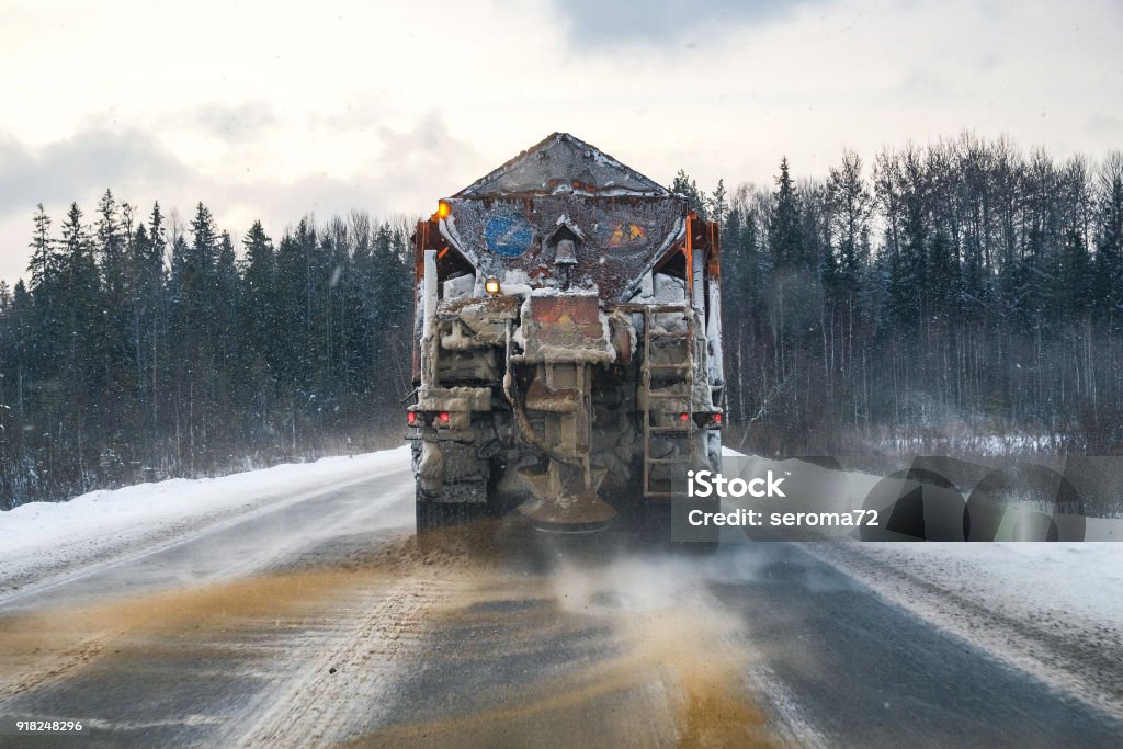 a snowplow on the highway snowplow on the highway throws sand and salt Ice Stock Photo