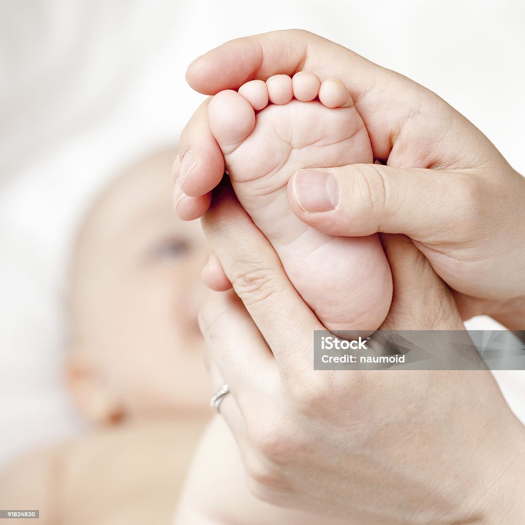 Two hands massaging a baby's foot Mother massaging her child's foot, shallow focus Child Stock Photo