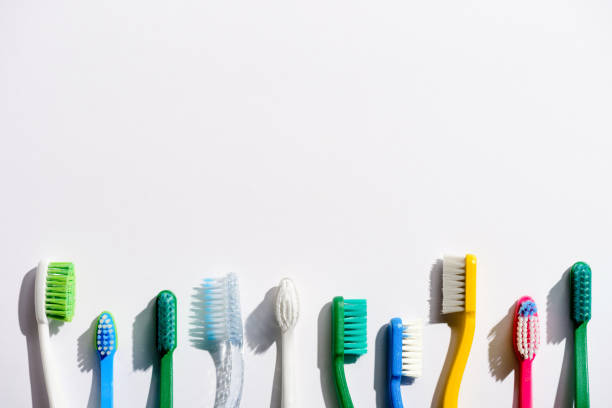 rząd różnych szczoteczek do zębów, na białym z przestrzenią do kopiowania - toothbrush zdjęcia i obrazy z banku zdjęć