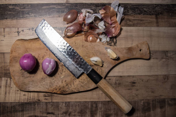istock Onion, garlic and sharp knife with wooden cutting board 918248880