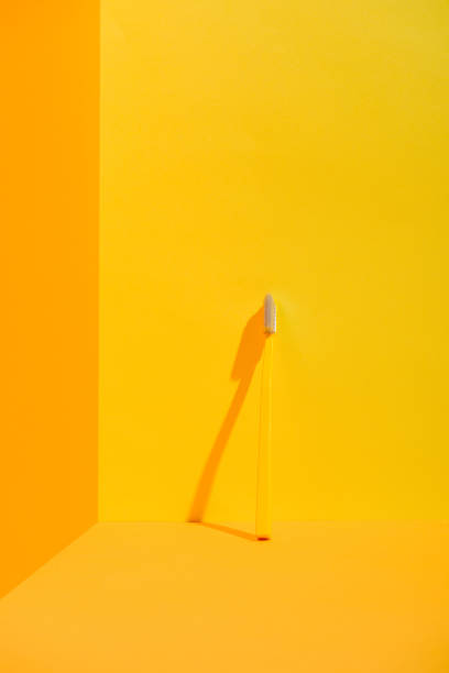 istock yellow toothbrush standing at orange wall 918251242