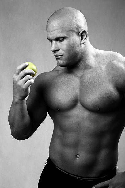 homem forte com maçã - abdominal muscle extreme sports sensuality sex symbol - fotografias e filmes do acervo