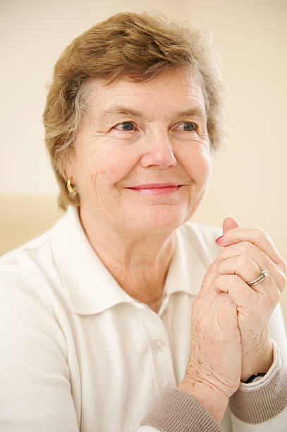 istock Smiling Female Senior Citizen with Hands Clasped in Joy 91825684