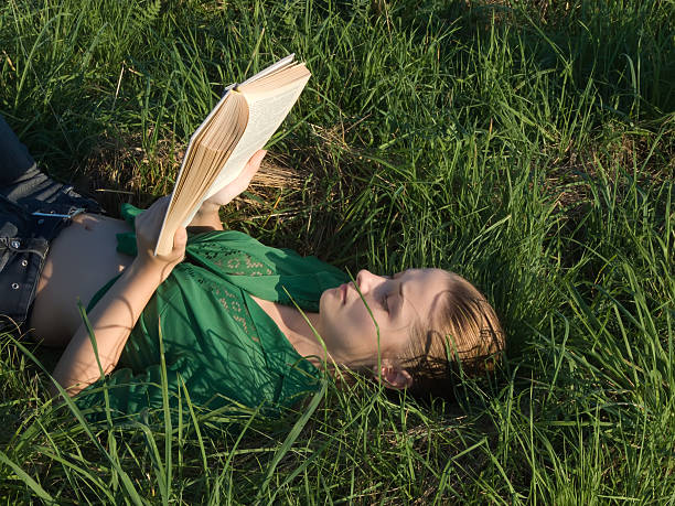 istock Girl reading at green grass from meadow 91825956