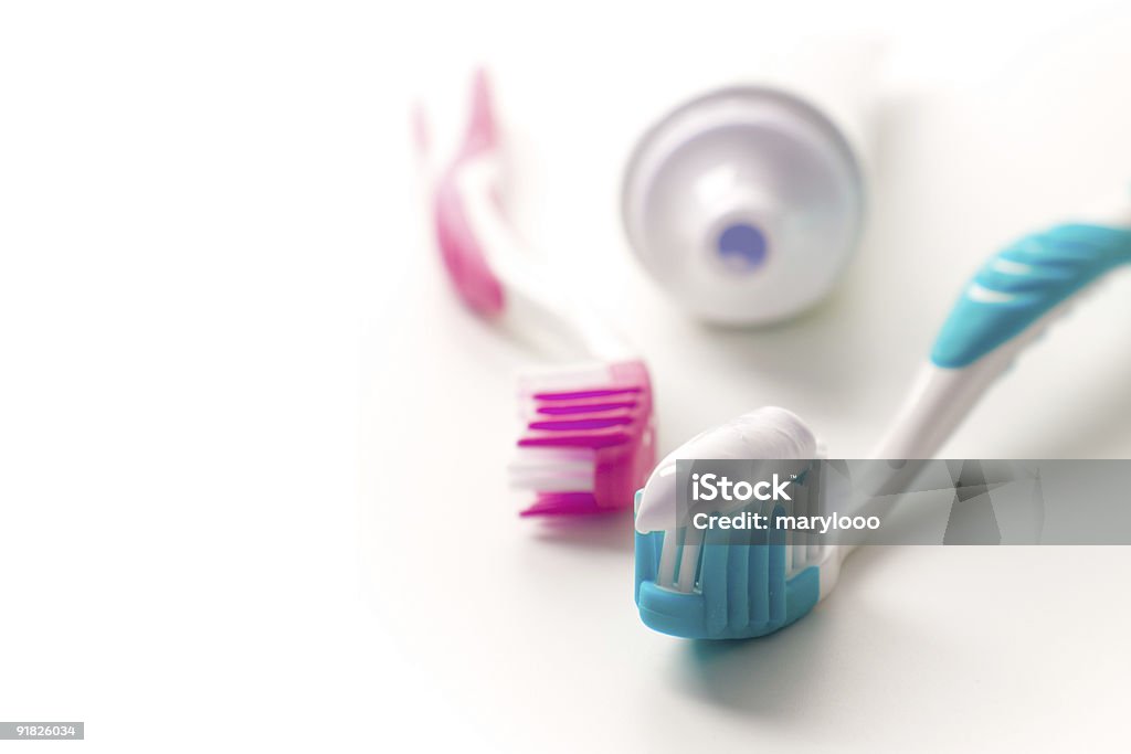 Pink and blue toothbrushes and toothpaste tube toothpaste and toothbrushes closeup. dental care Blue Stock Photo