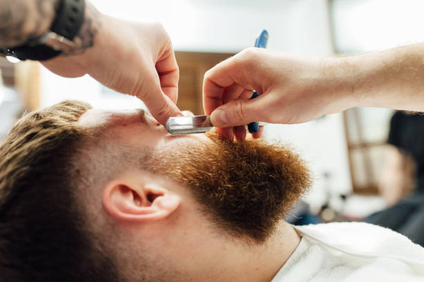 istock Close up image of barber makes beard cut of a man 918263124