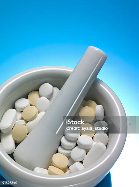 Mortar And Pestle With Pills On Blue Background Stock Photo - Download Image Now - Mortar and Pestle, Pill, Capsule - Medicine