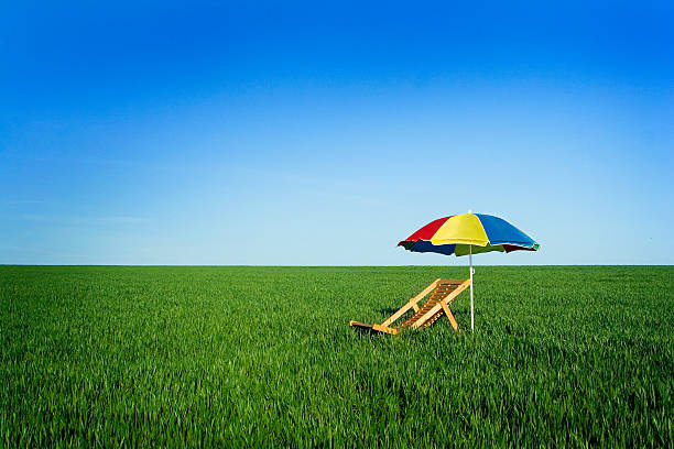 Summer chair colorful umbrella left at meadow. Relaxation and le stock photo